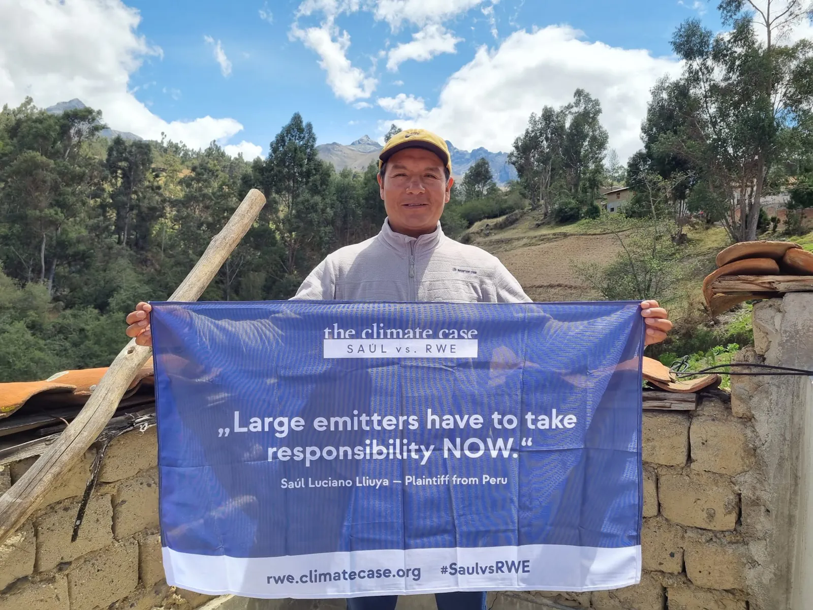 Das Foto zeigt Saúl aus Huaraz, der ein Banner hält, mit der Aufschrift: "Large emitters have to take responsibility NOW."