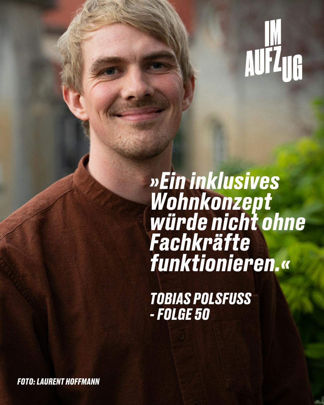 Porträt von Tobias Polsfuß, einem jungen Mann mit kurzen blonden Haaren und einem sanften Lächeln. Er trägt ein dunkelbraunes Cordhemd und blickt direkt in die Kamera. Im Hintergrund ist eine unscharfe urbane Szene. Über ihm ist in großen weißen Buchstaben "IM AUFZUG" zu lesen, und darunter steht ein Zitat: "Ein inklusives Wohnkonzept würde nicht ohne Fachkräfte funktionieren." – TOBIAS POLSFUSS - FOLGE 50. Am unteren Bildrand wird das Foto Laurent Hoffmann zugeschrieben.