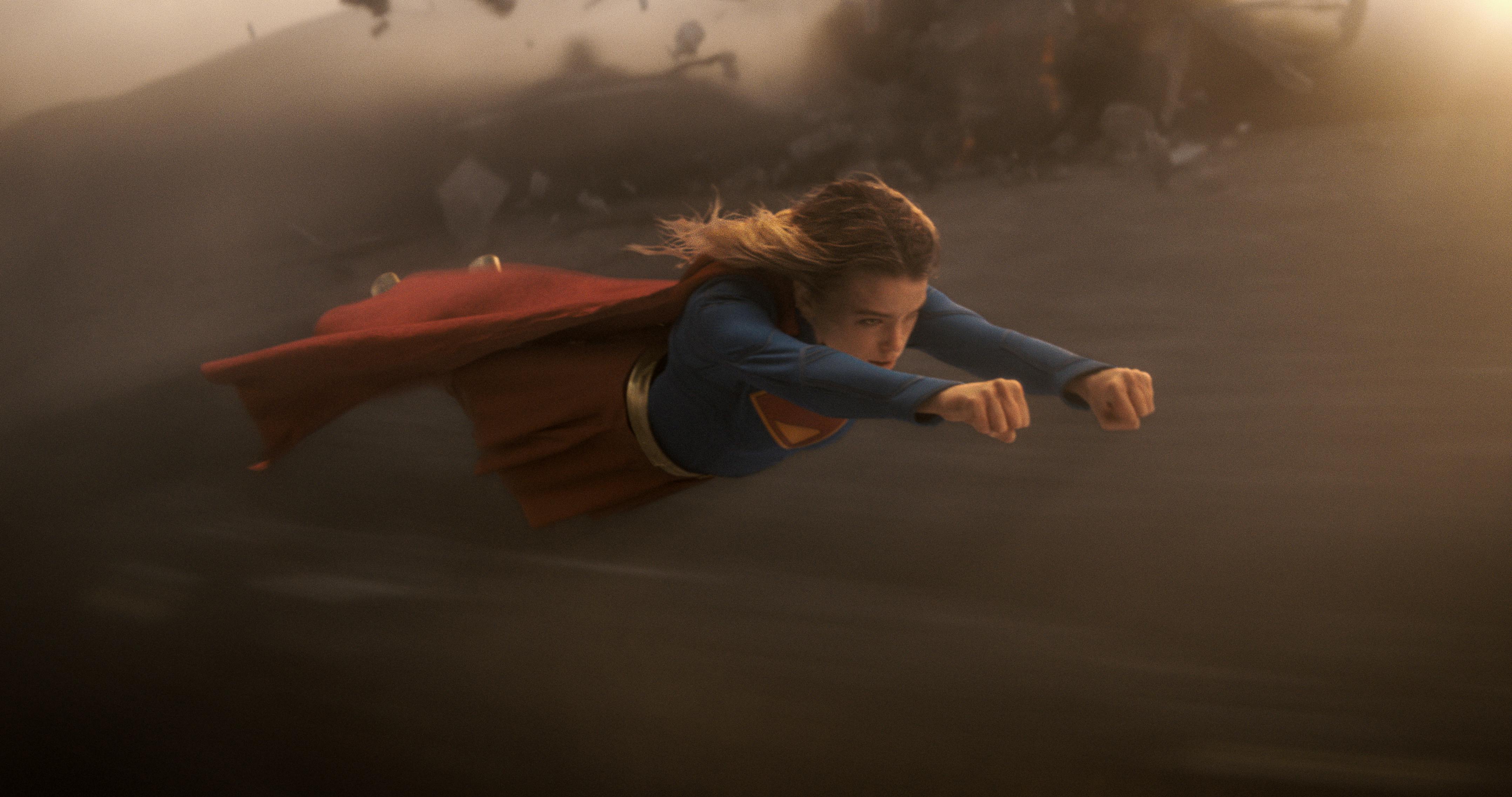 Milly Alcock fliegt als Supergirl über Sand während eines Kampfes //  © 2026 Warner Bros. Ent. All Rights Reserved / Photo Credit: Courtesy of DC Studios and Warner Bros. Pictures