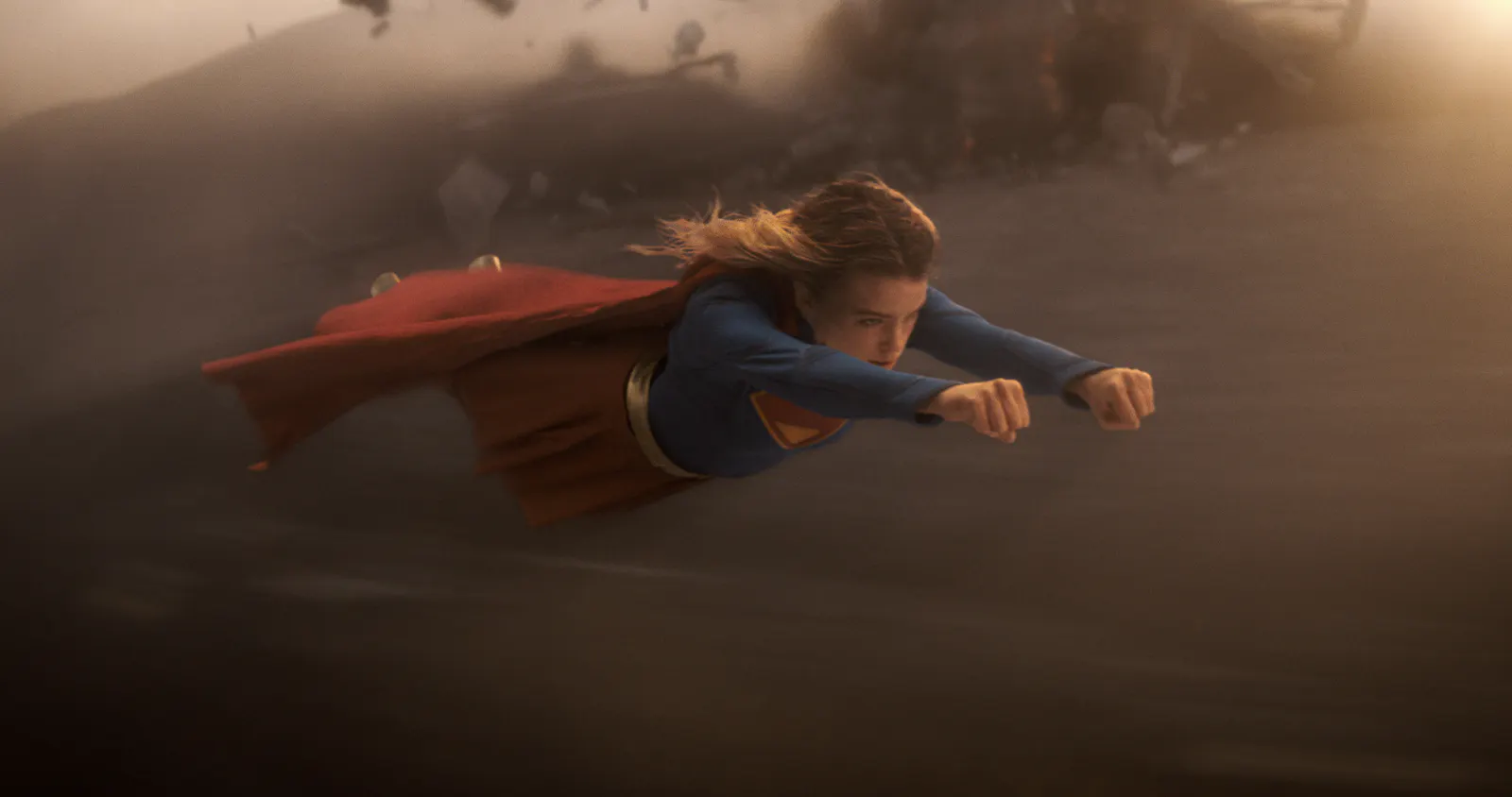 Milly Alcock fliegt als Supergirl über Sand während eines Kampfes // © 2026 Warner Bros. Ent. All Rights Reserved / Photo Credit: Courtesy of DC Studios and Warner Bros. Pictures