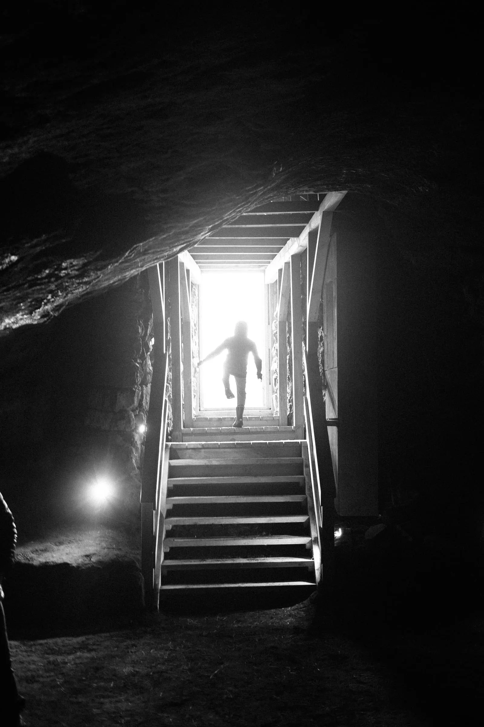 The silhouette of a child stepping out of a cave
