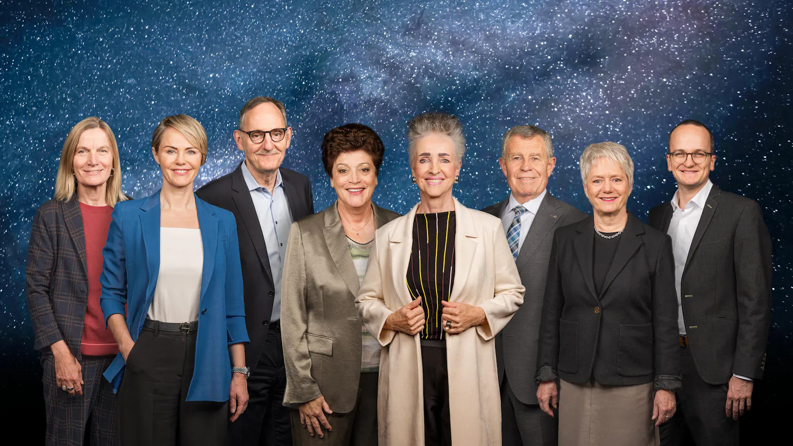 Zürcher Regierungsrat vor galaktischer Sternenkulisse; acht Mitglieder posieren als offizielle Gruppe für das Amtsjahr 2026/27.
