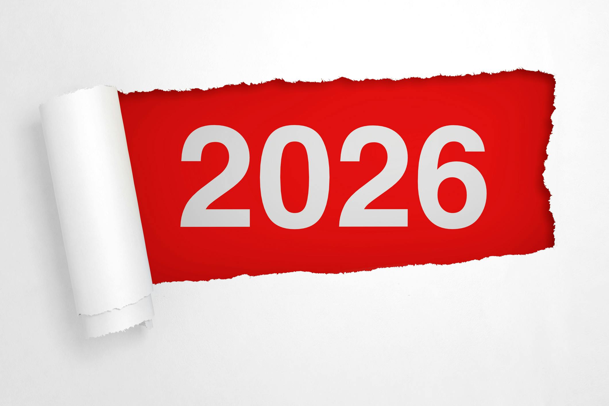 Dieses Foto zeigt ein aufgerissenes weißes Papier. Darunter ist ein rotes Feld mit der weißen Zahl 2026 zu sehen.