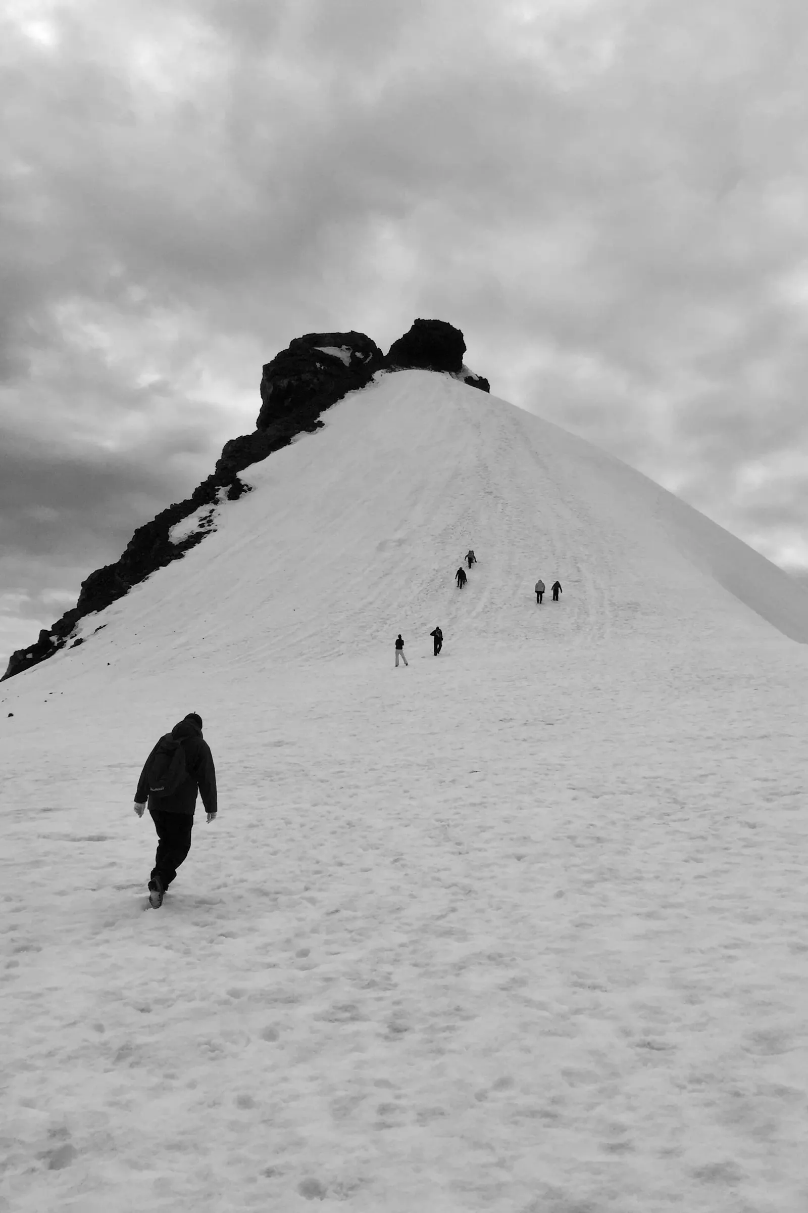 A group of people are walking up to the peak of Snæfellsjökull