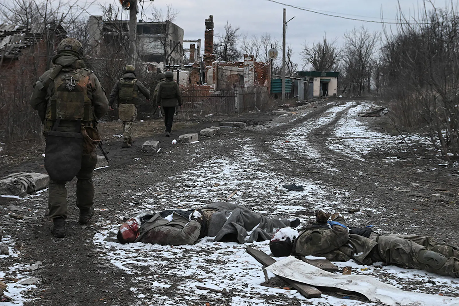 Russische Soldaten gehen an gefallenen Ukrainern vorbei.