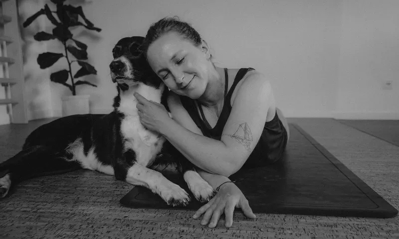 Bild von Nici und Hund Piet, beide liegen auf der Yogamatte und kuscheln