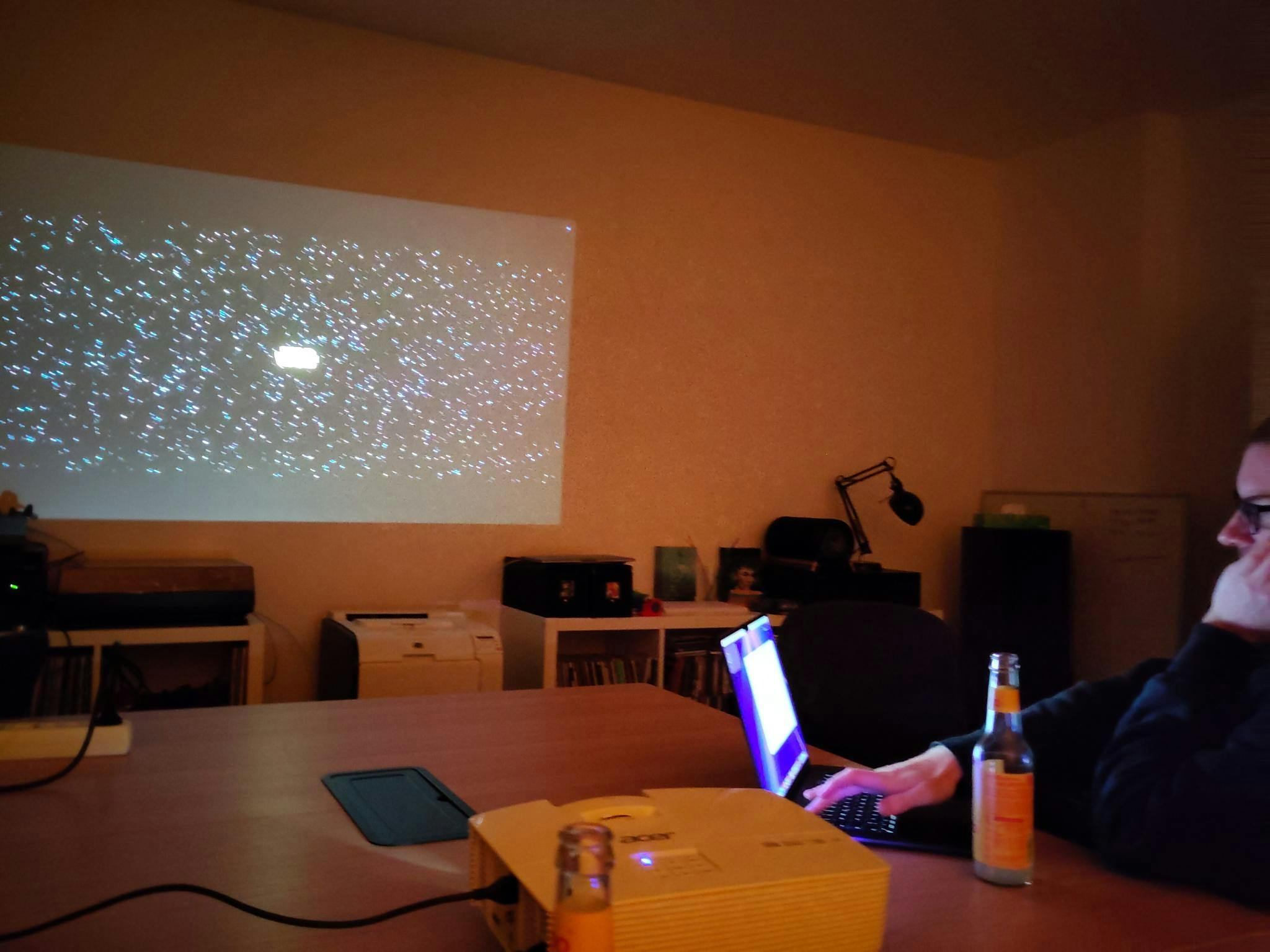 Christian sitzt an seinem Laptop und im Hintergrund projiziert ein Beamer den Film "Star Wars: Episode VII – Das Erwachen der Macht".