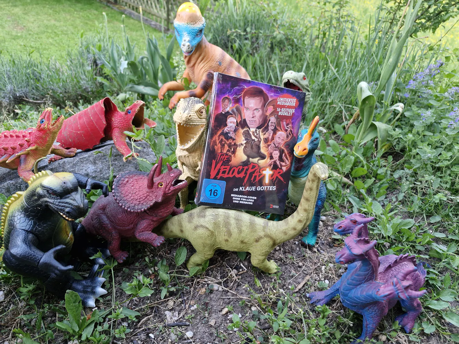 Velocipastor Mediabook mit verschiedenen Spielzeug Dinosaurier