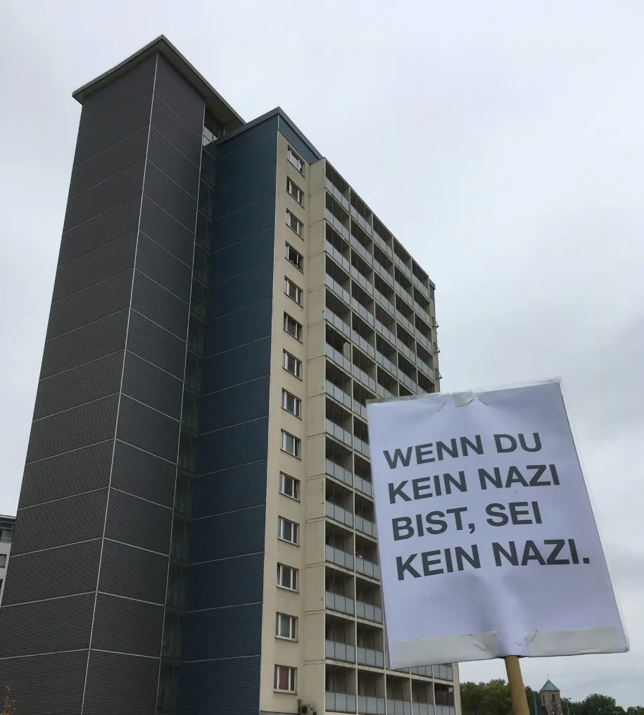 Demoplakat vor Hochhaus: Wenn du kein Nazi bist, sei kein Nazi.