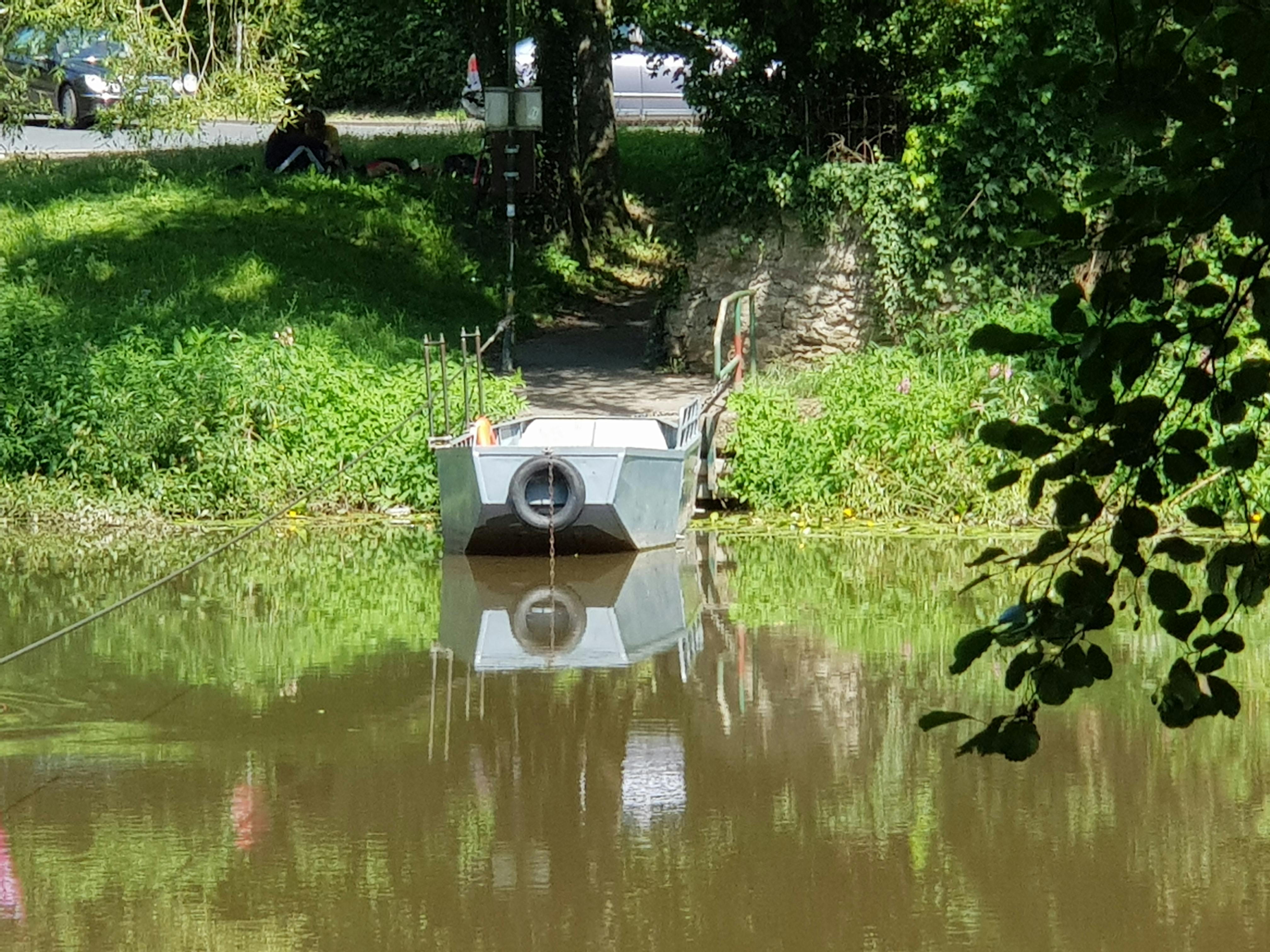 Auf dem Bild ist ein graues Rollschiff gesehen, welches mit Muskelkraft über die Lahn gezogen wird