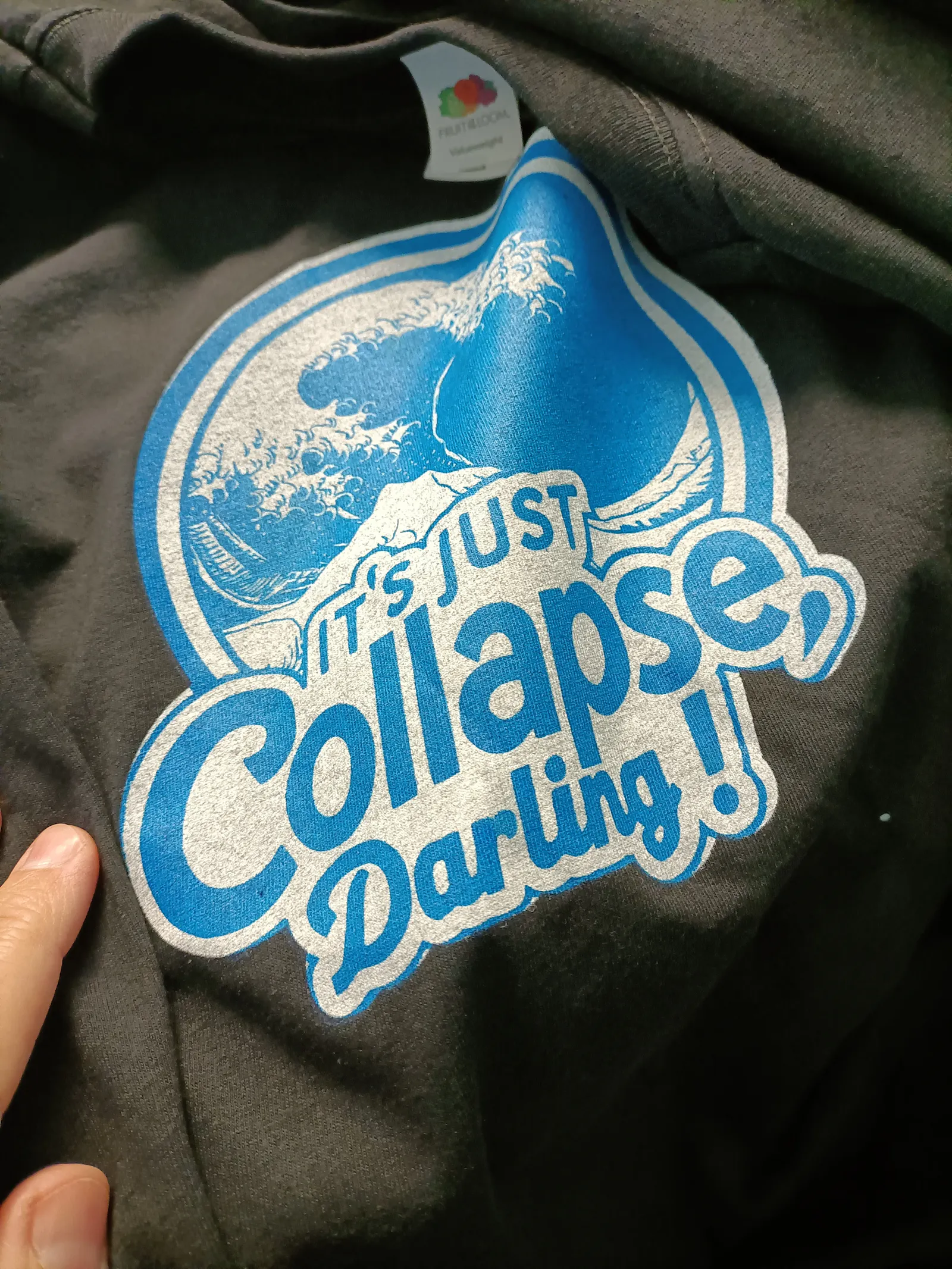 schwarzer Tshirt mit blauem Aufdruck einer Welle und dem Schriftzug "It's just collapse, darling"