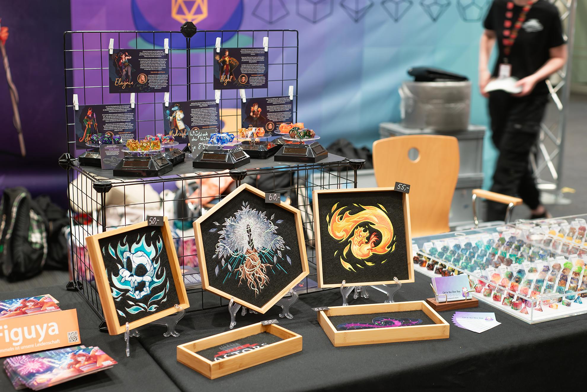 Der Merch-Stand mit Dice Trays von unter anderem Gynther, dem Silberbaum und Fridolin sowie ganz viele Würfel.
