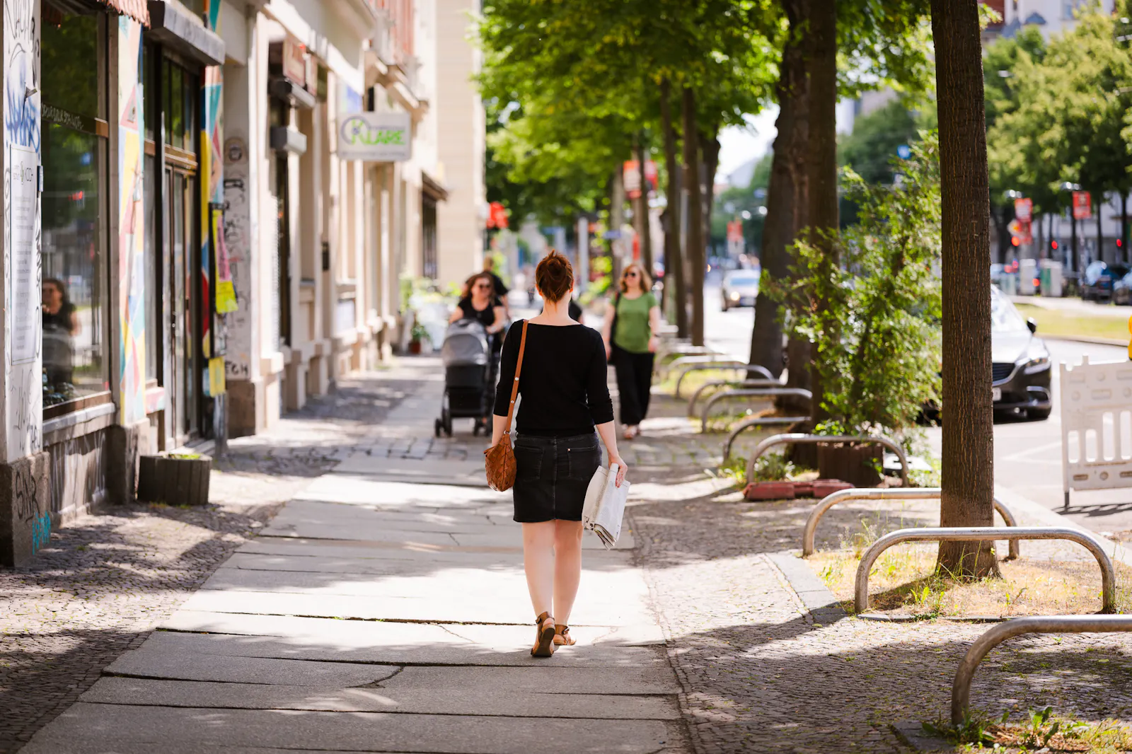 Insa van den Berg, Frau mit roten Haaren, läuft einen Fußweg entlang. Sie hat eine Zeitung in der Hand und der Kamera den Rücken zugewandt. Foto: Roland Kersting