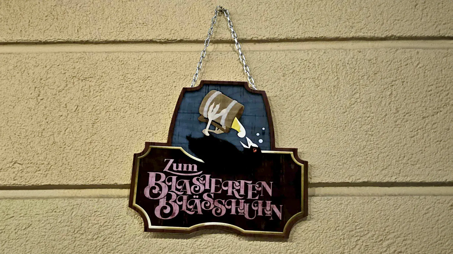 Ein aufwÀndig gestaltetes Tavernenschild mit der Aufschrift: "Zum Blasierten BlÀsshuhn"
