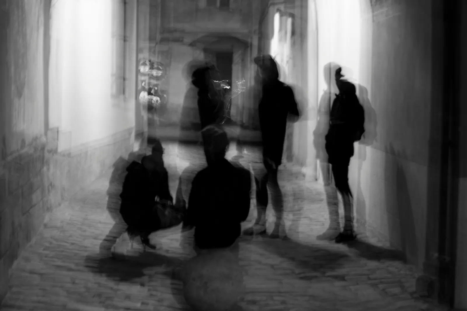Ein schwarz-weiß Bild, 5 Personen in einer Gasse. Das Bild ist unscharf aufgenommen.
