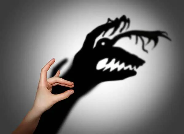 Schattenspiel vor einer Wand, an dieser entsteht ein Monster