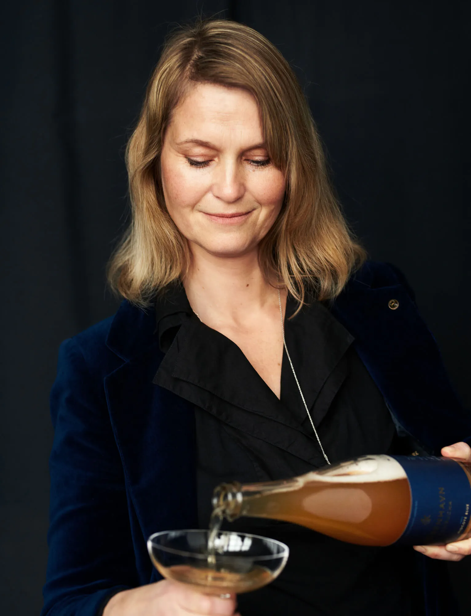 Louise Benkjær Limbach schenkt aus einer Flasche in ein Glas ein