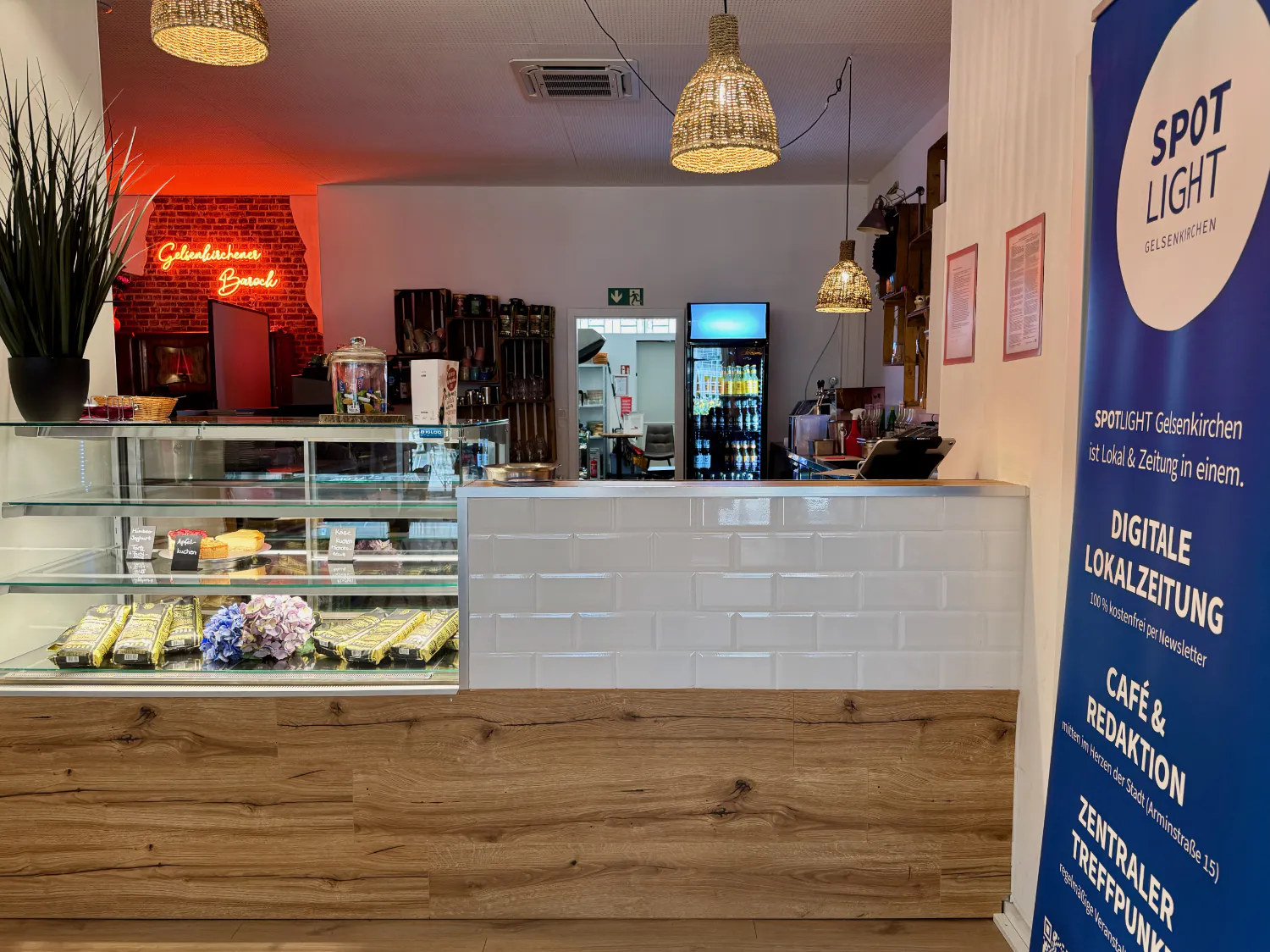 Die Theke des Cafés mit einem Spotlight-Banner davor auf der rechten Seite