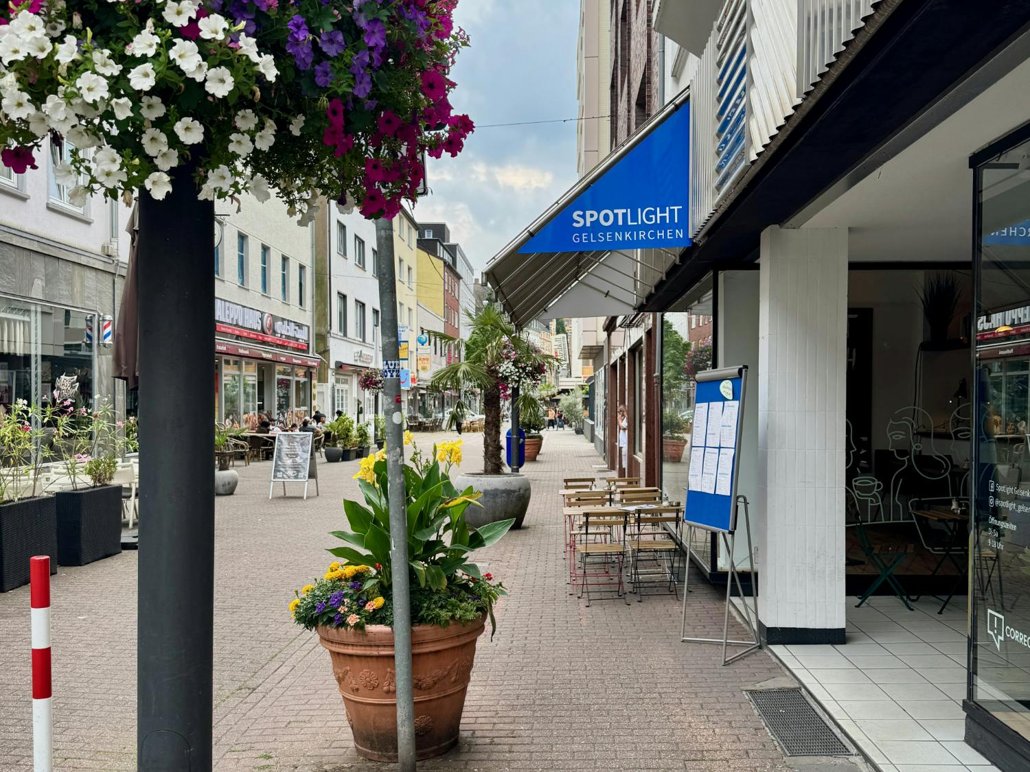 Blick in die mit Blumentöpfen verschönerte Arminstraße in Gelsenkirchen mit dem Eingang des Spotlight-Cafés auf der rechten Seite