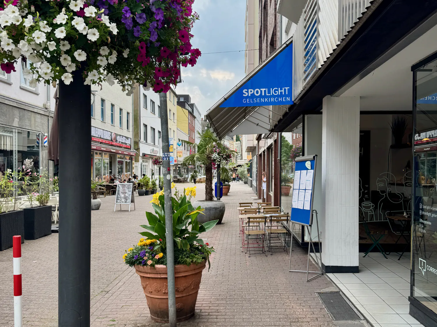 Blick in die mit Blumentöpfen verschönerte Arminstraße in Gelsenkirchen mit dem Eingang des Spotlight-Cafés auf der rechten Seite