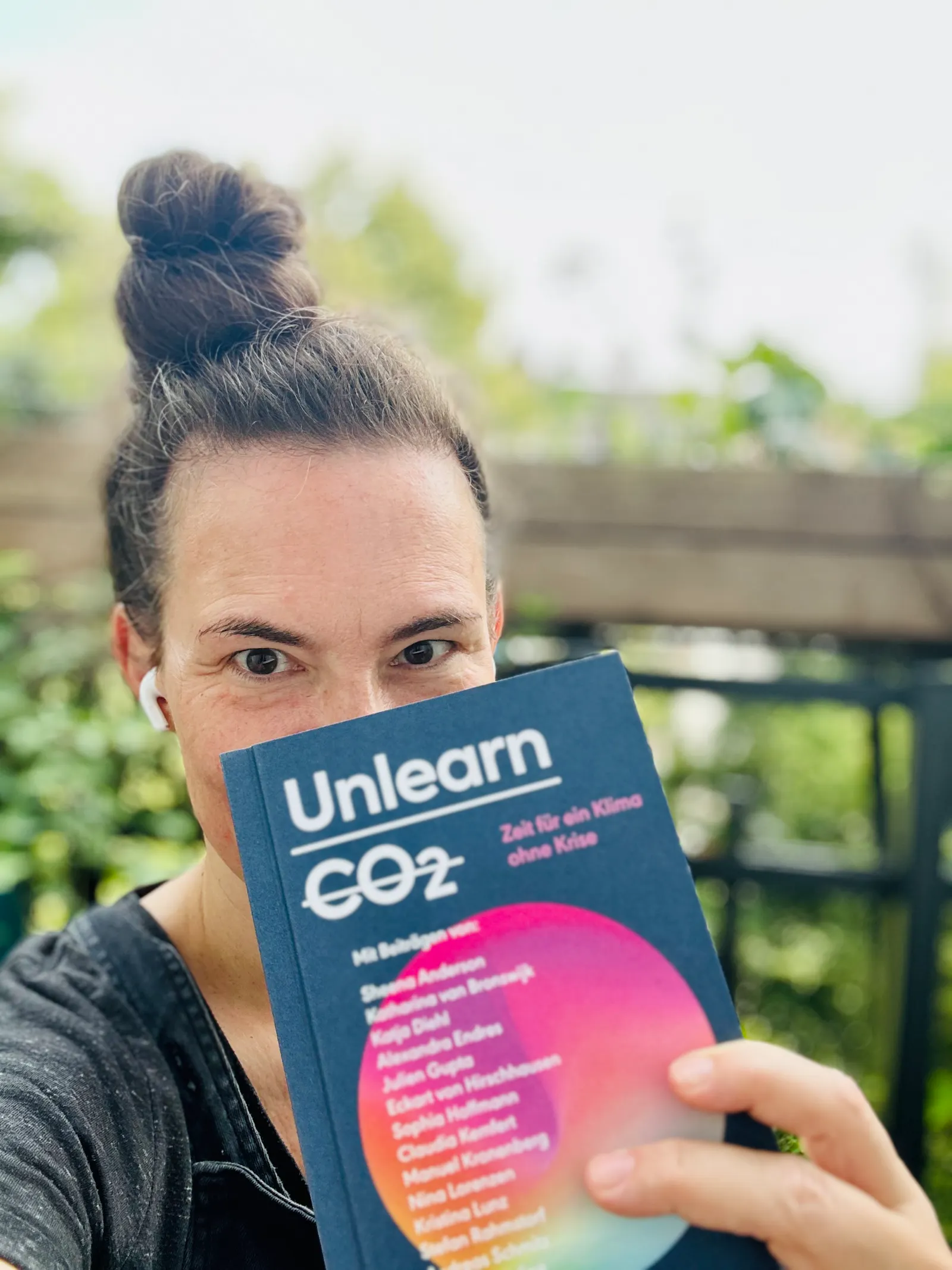 Ich halte das Buch Unlearn CO2 in die Kamera.