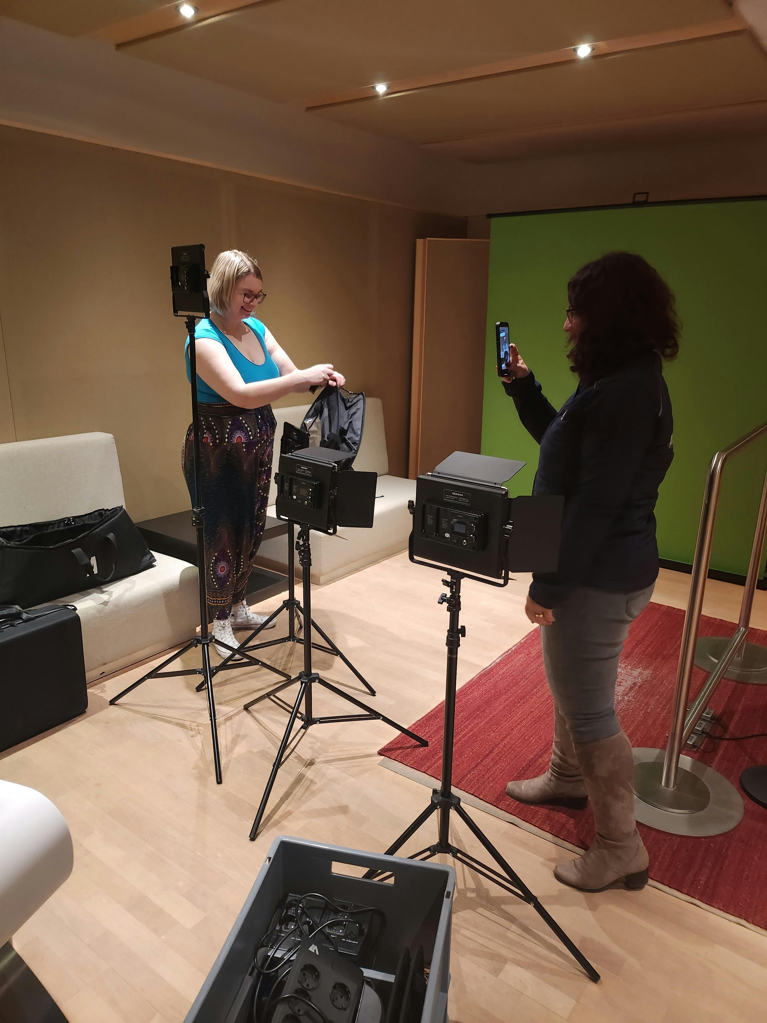 Carina und Aylin, die Technik vor einem Greenscreen aufbauen.