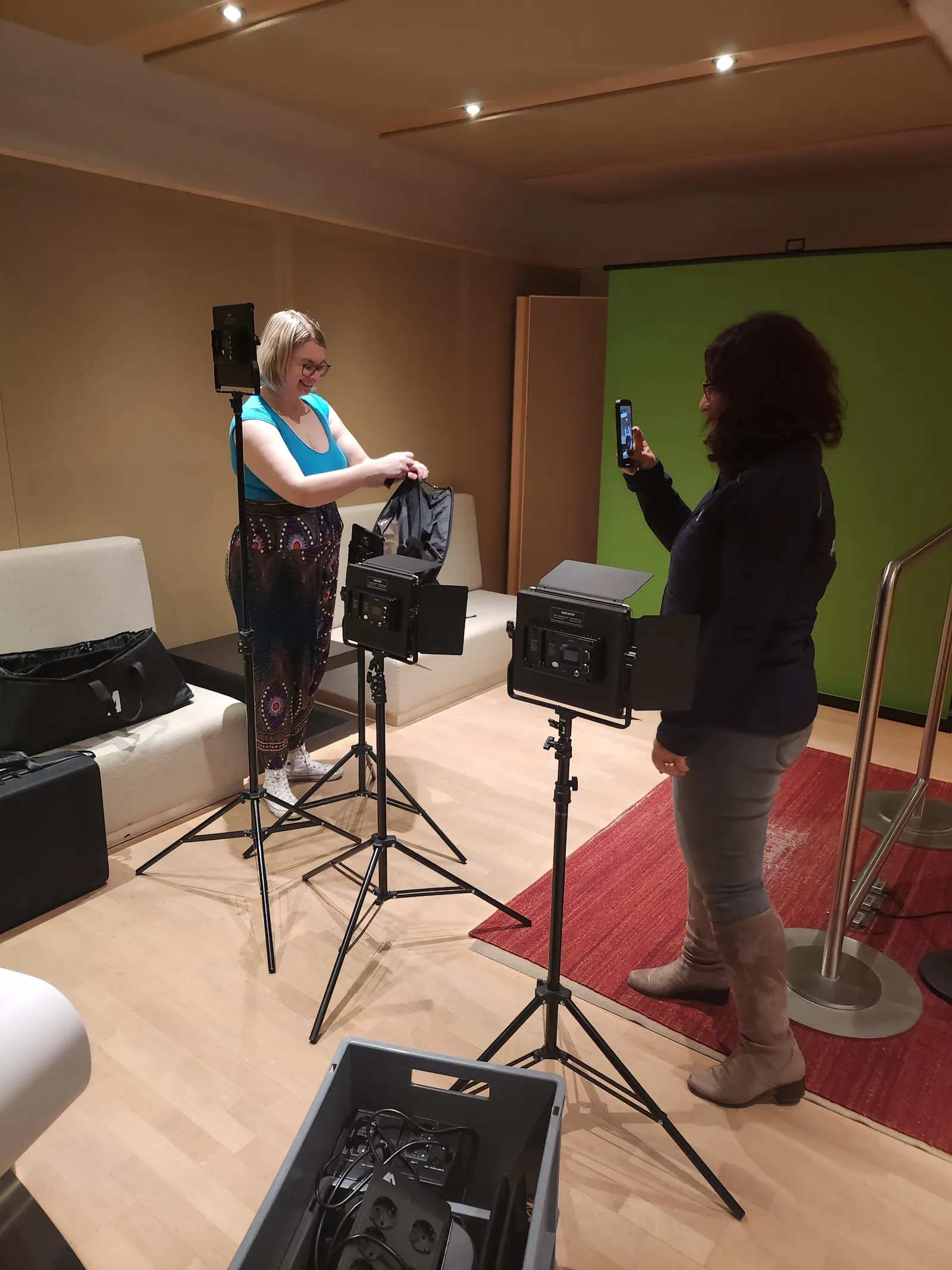 Carina und Aylin, die Technik vor einem Greenscreen aufbauen.