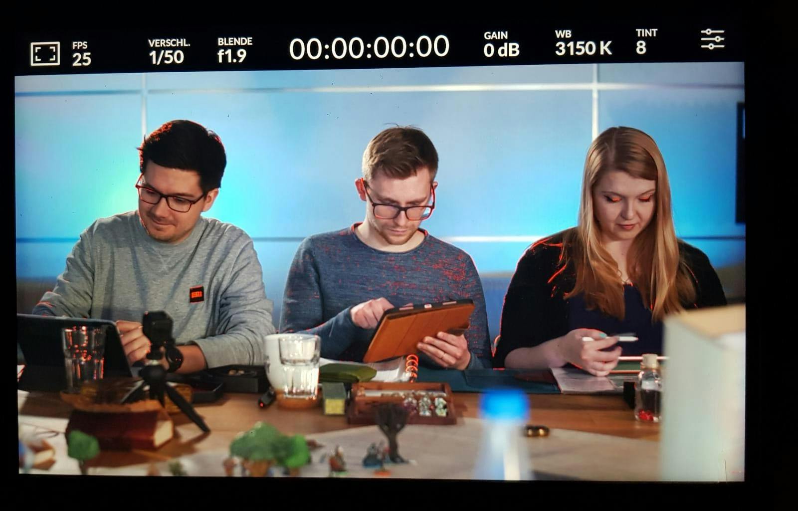 Patze, Christian und Rieke, die am Spieltisch singen. Es ist ein abfotografiertes Bild des Kamera-Displays.