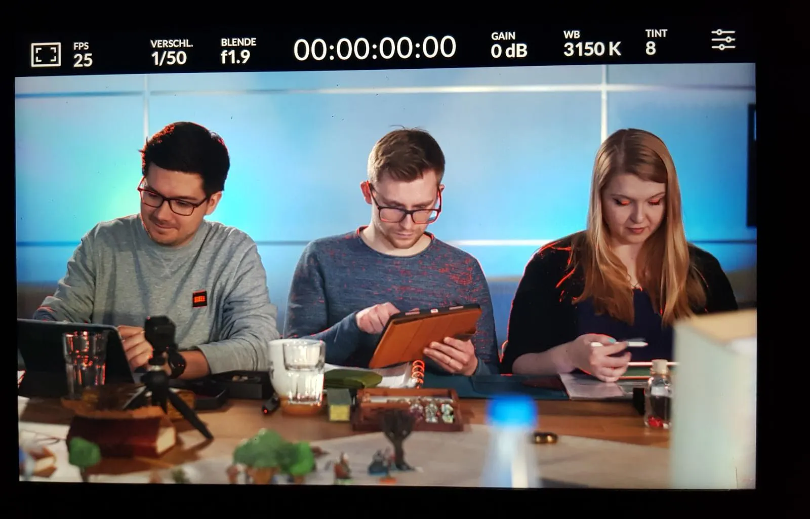 Patze, Christian und Rieke, die am Spieltisch singen. Es ist ein abfotografiertes Bild des Kamera-Displays.