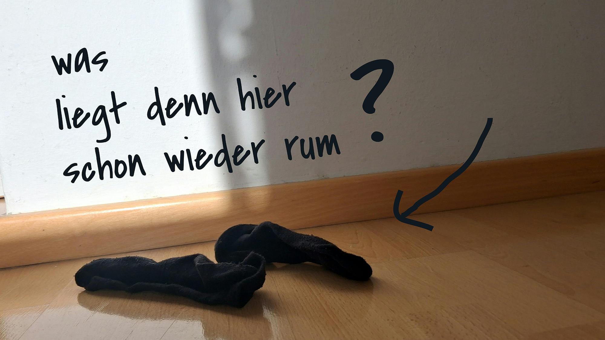 In einer Wohnung liegen gebrauchte Socken auf dem Boden.