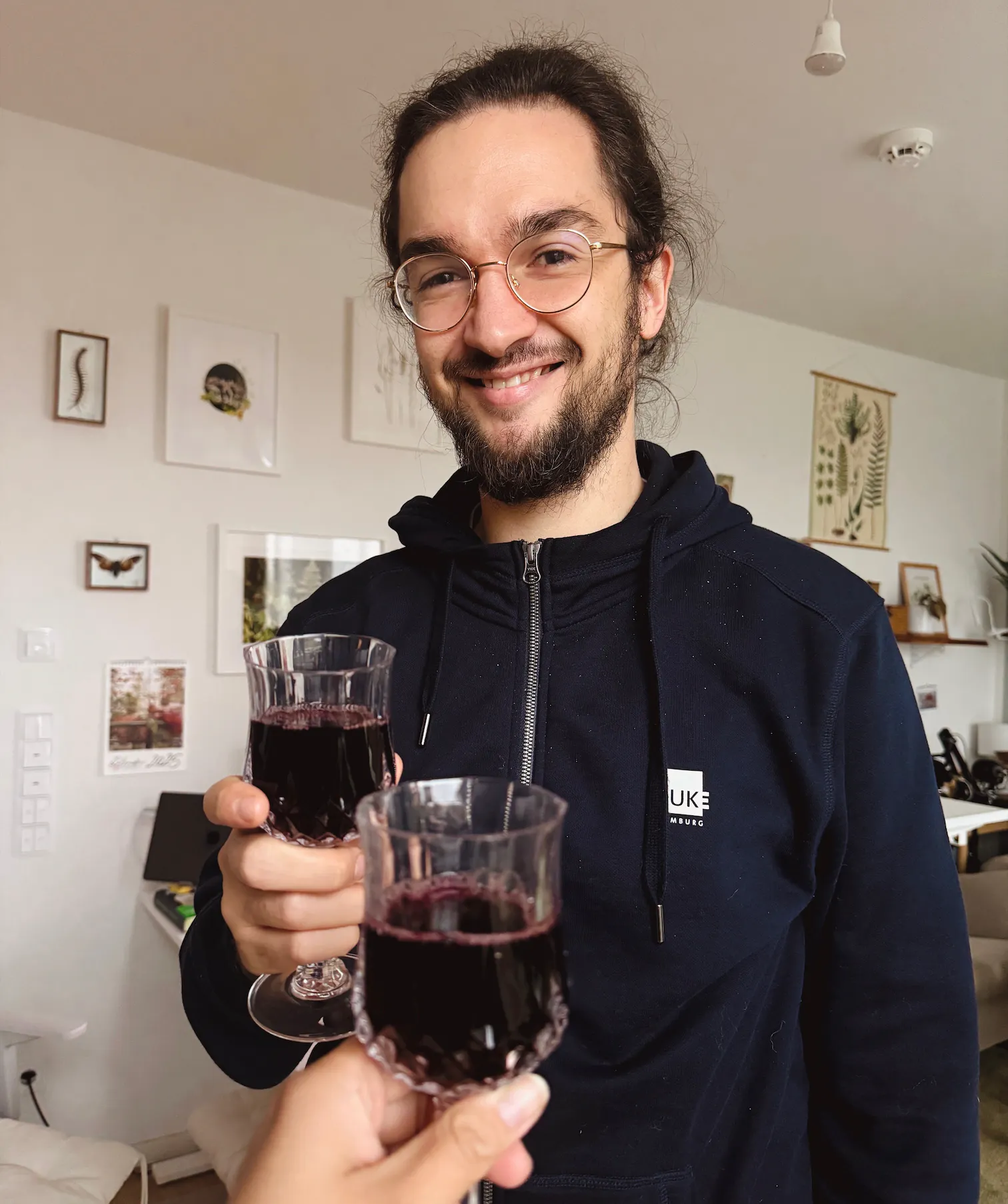 Lorenz stößt mit einem Glas entalkoholisiertem Rotwein an.