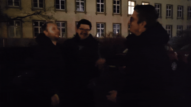 GIF-Datei: Die Dice Actors stehen draußen im Dunkeln beisammen und umarmen sich zum Abschied, bevor alle nach Hause fahren.