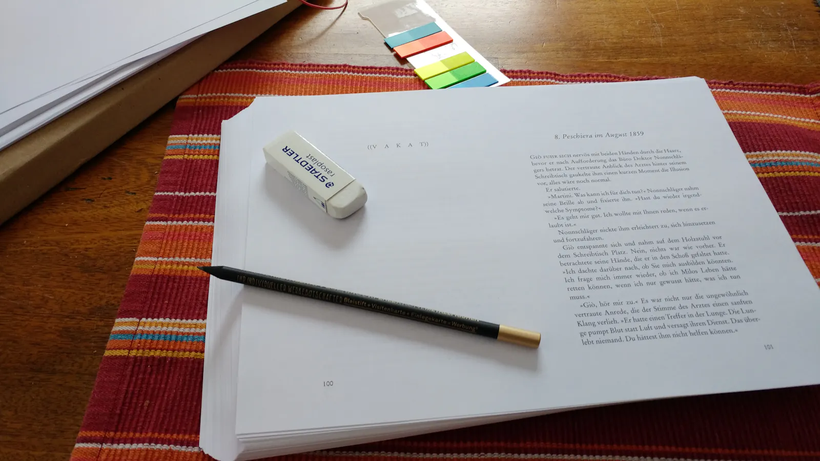 Ein Manuskriptstapel mit Bleistift und Radiergummi