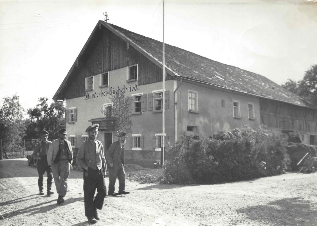 Das historische schwarz-weiß Foto zeigt vier Männer vor dem Wanderhof Bischofsfried.