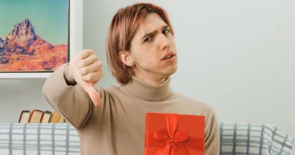 Mann mit einem vermeintlichen Geschenk, enttäuschtem Gesicht und Daumen nach unten-Geste / Bild: Freepik, stockking